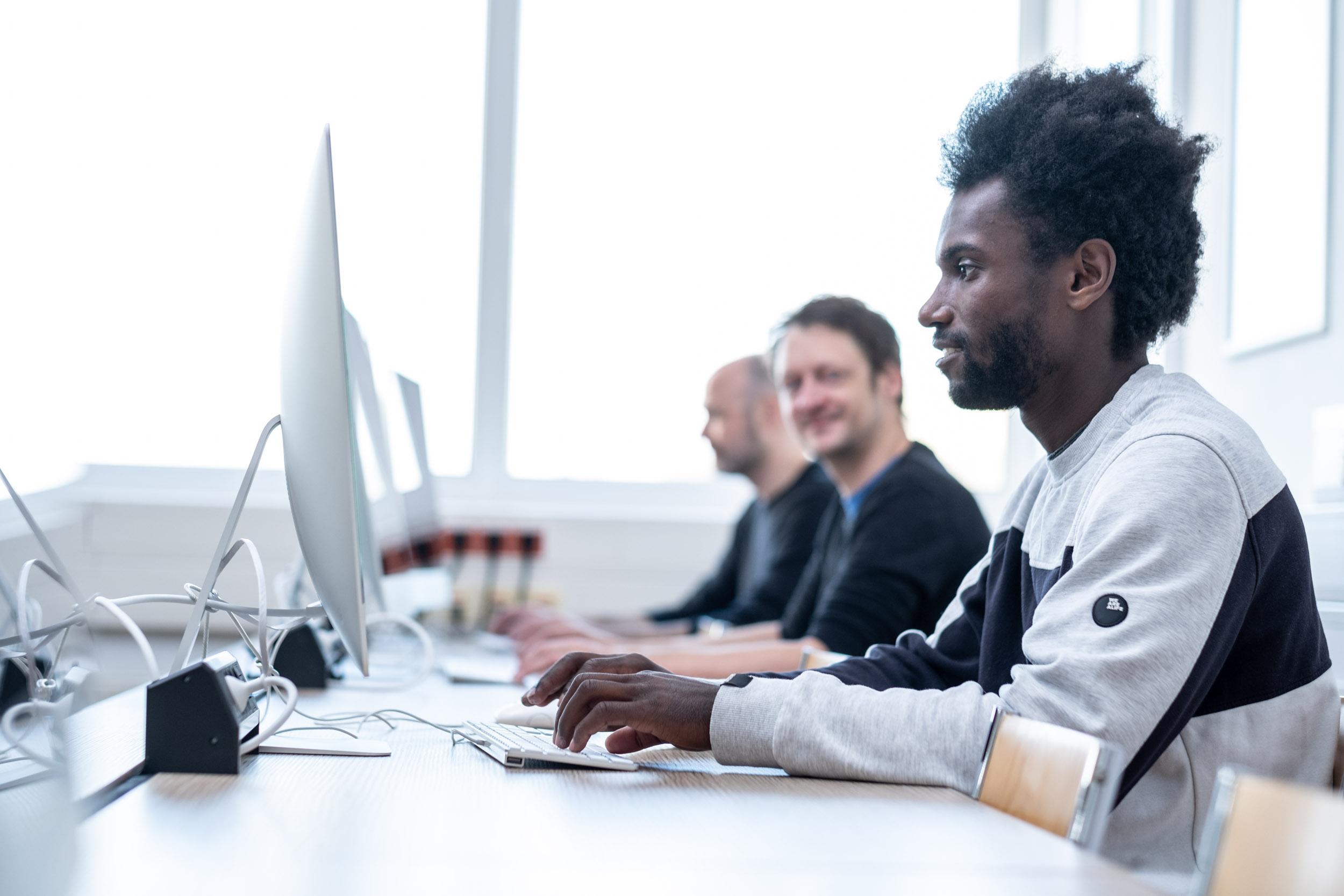 Studierende vor Mac-Computern