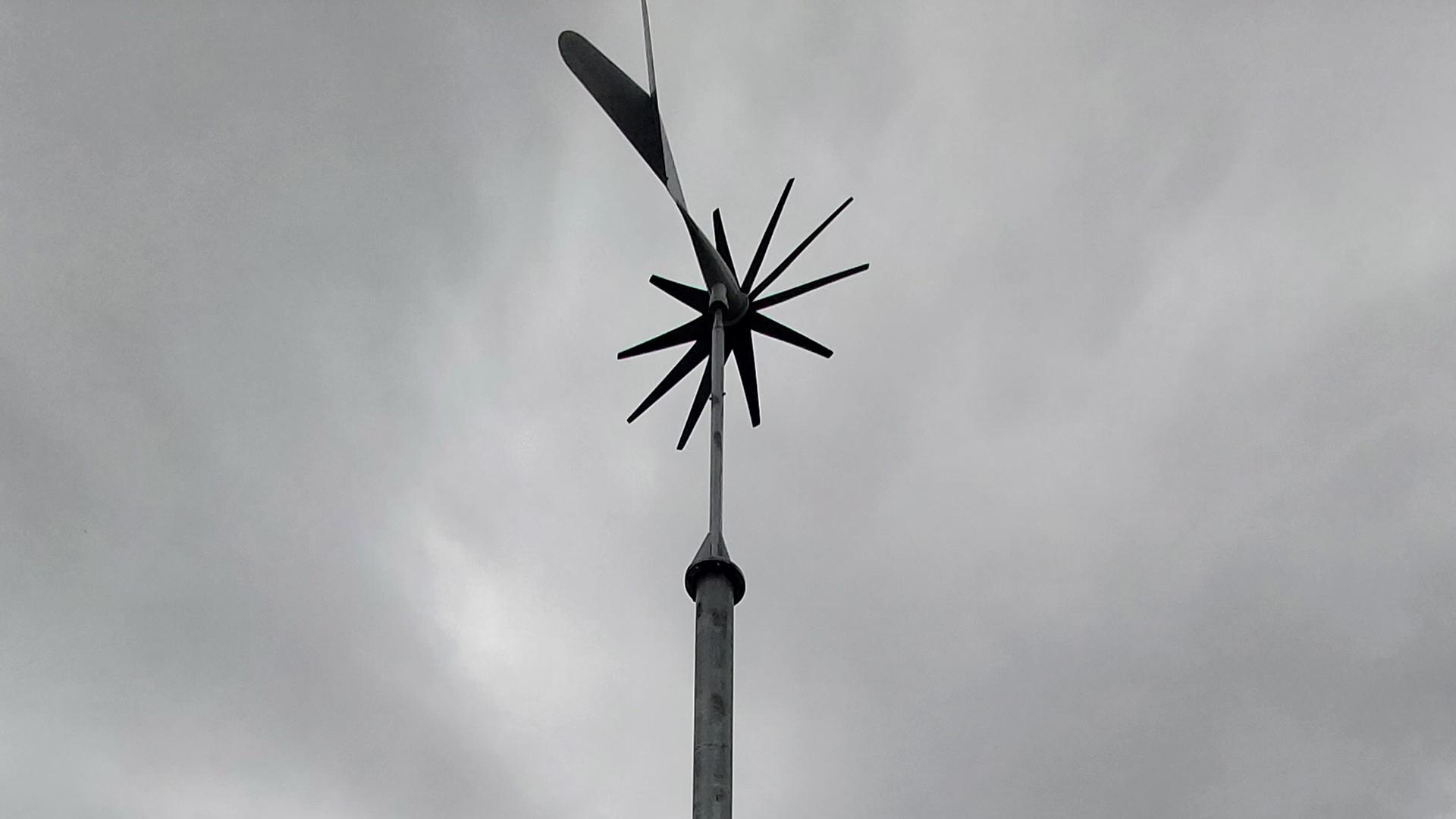 kleinwindkraftanlage vor grauen wolken