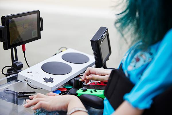 A person in a wheelchair playing nintendo switch with adaptive gaming input devices.