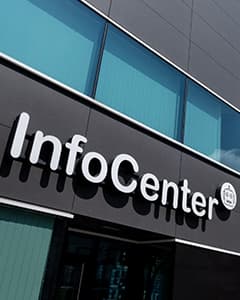 Das Äußere eines modernen Gebäudes mit großen Fenstern und einem Schild mit der Aufschrift InfoCenter in fetten weißen Buchstaben.