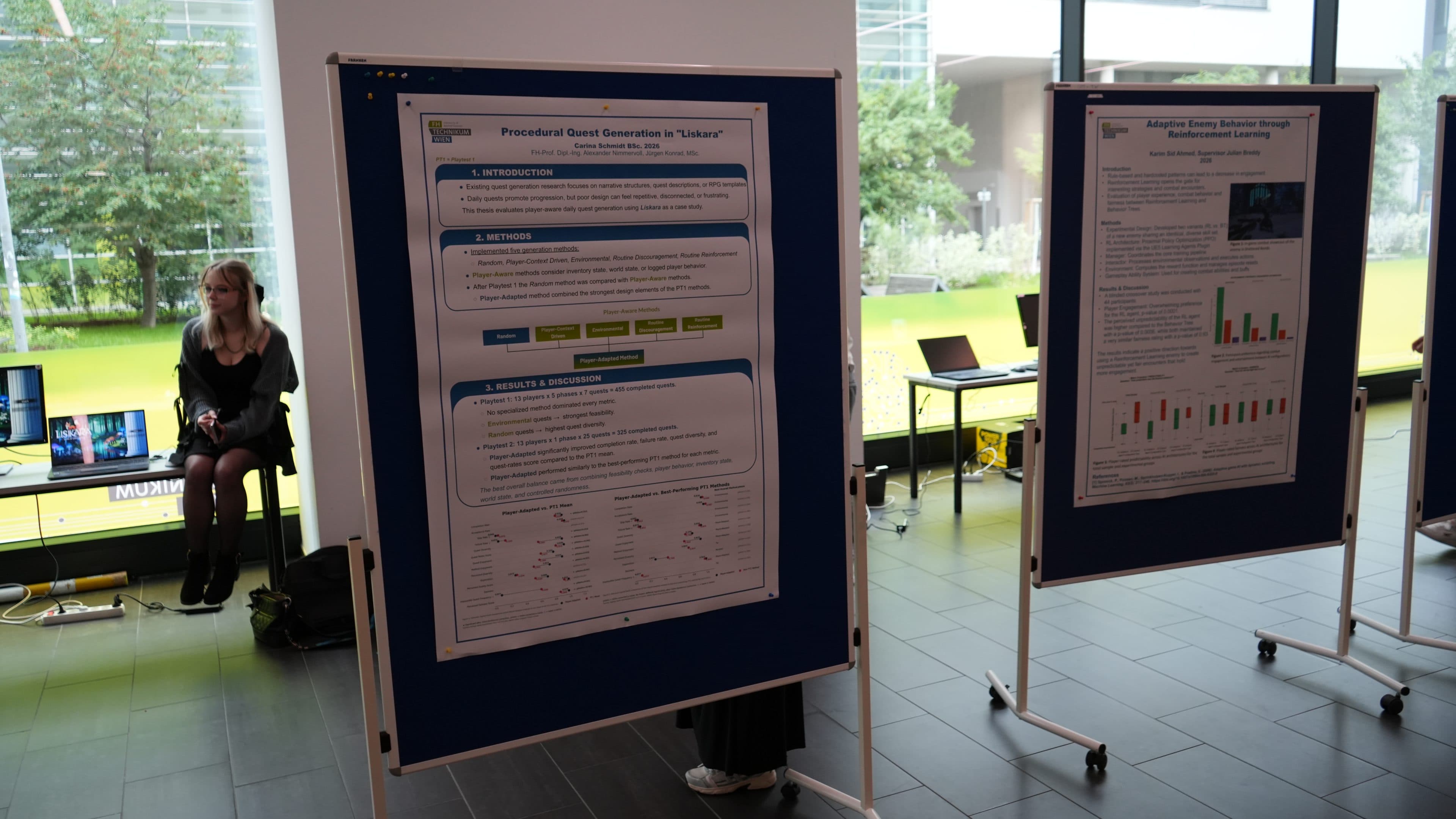 Eine Ausstellung mit wissenschaftlichen Postern auf blauen Tafeln in einem hellen Innenraum, im Hintergrund sitzt eine Person auf einer Bank in der Nähe großer Fenster mit Blick auf die grüne Umgebung.