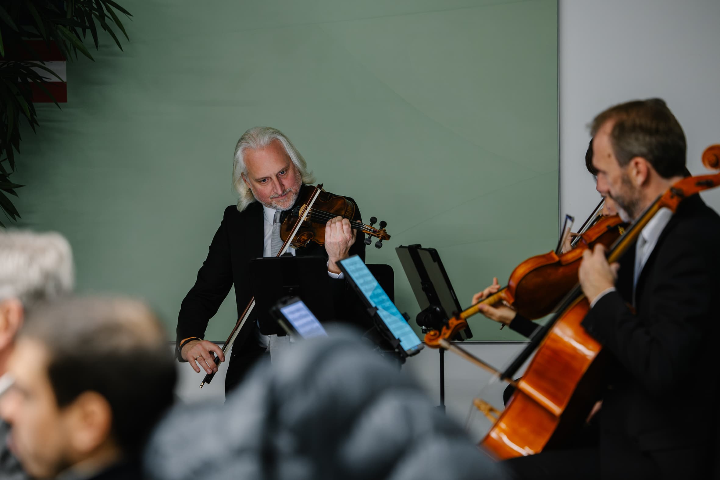 Ein Geiger und ein Cellist in festlicher Kleidung spielen gemeinsam.