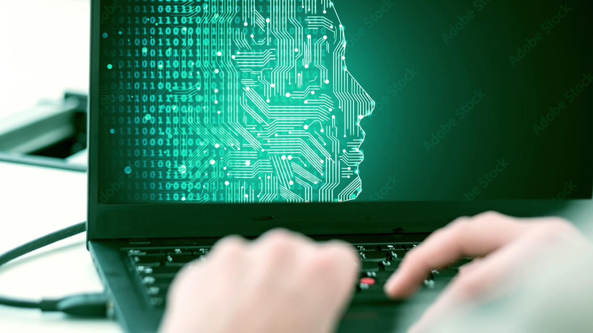 Nahaufnahme von Händen, die auf einer Laptoptastatur tippen, wobei der Bildschirm ein digitales menschliches Gesicht aus Schaltkreismustern und Binärcode anzeigt, das künstliche Intelligenz oder Technologie symbolisiert.