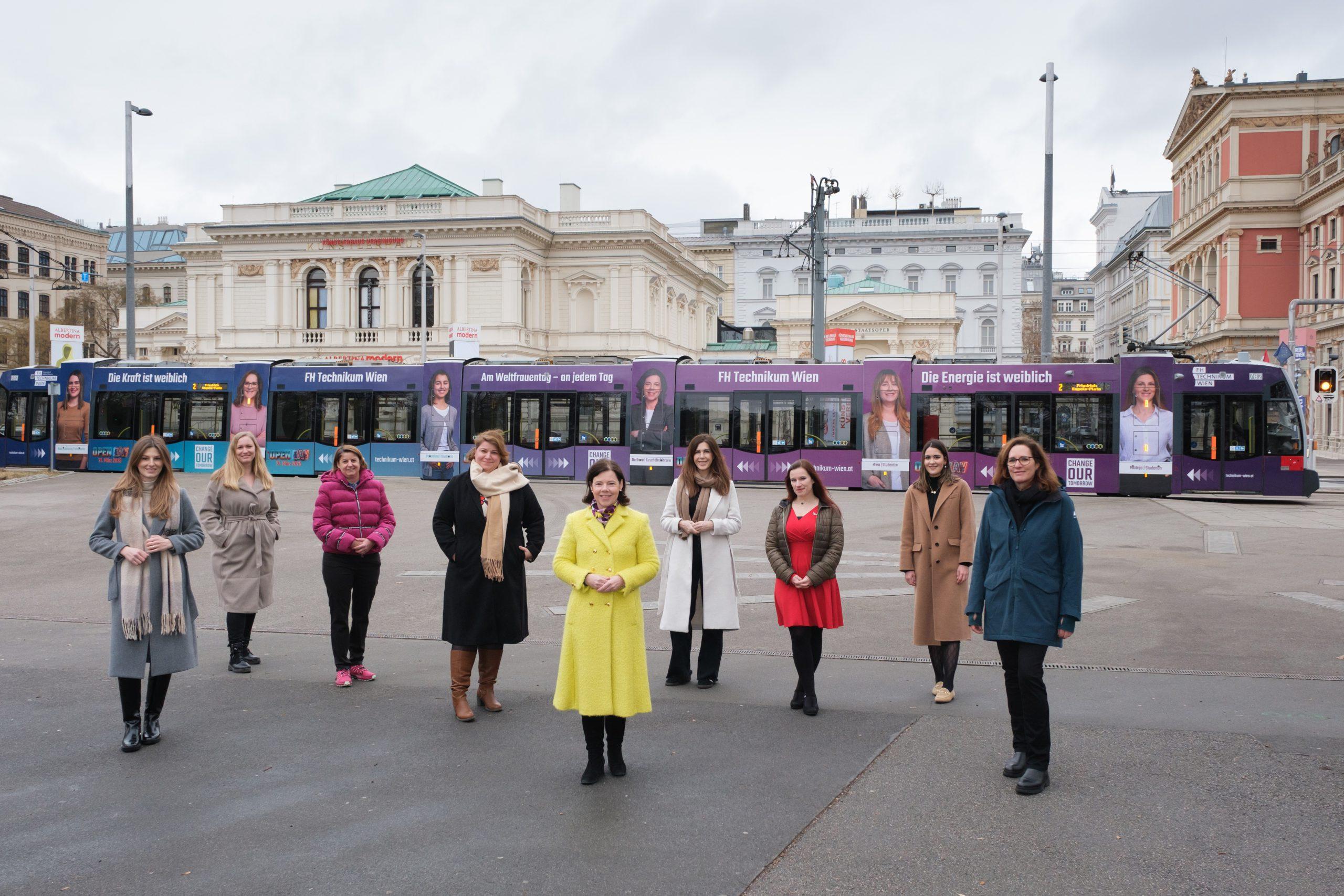 Gruppe von Frauen vor gebrandeter Straßenbahn