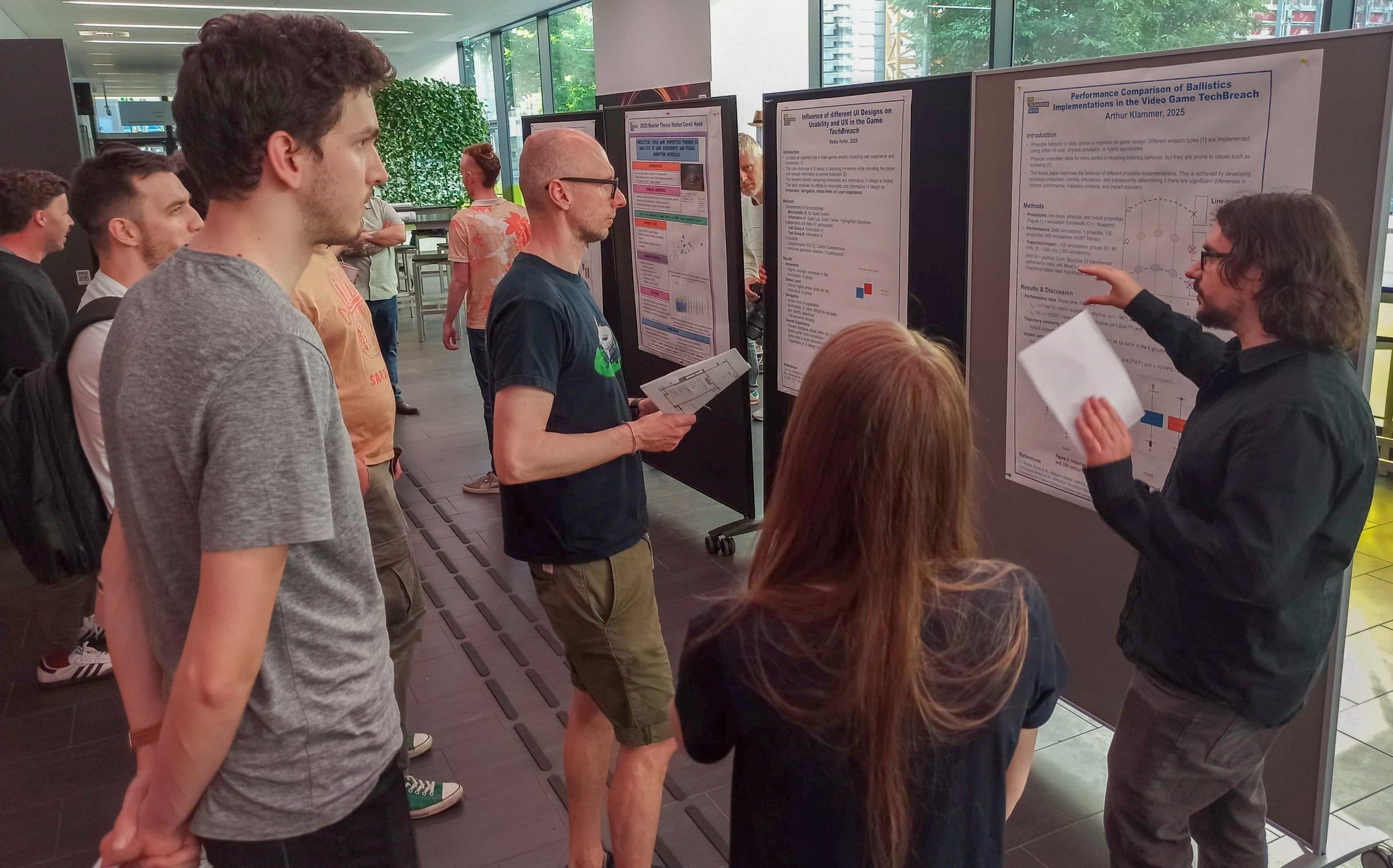 Eine Gruppe von Personen hört einem Vortragenden zu, der in einem gut beleuchteten Raum wissenschaftliche Poster auf Tafeln erklärt. Eine Person zeigt auf ein Poster, während die anderen beobachten oder Papiere halten.