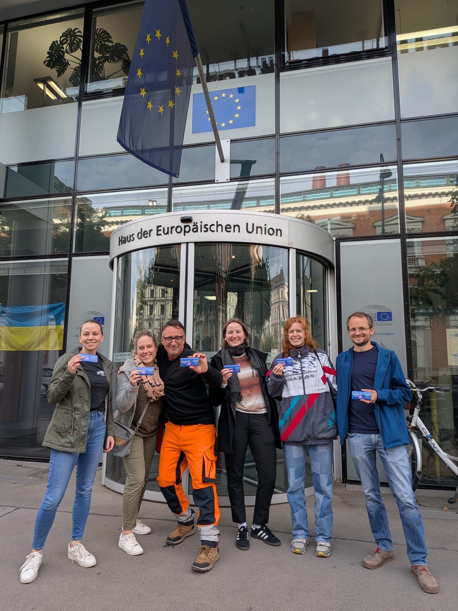 Eine Gruppe von Menschen posiert für ein Foto vor einem Gebäude.