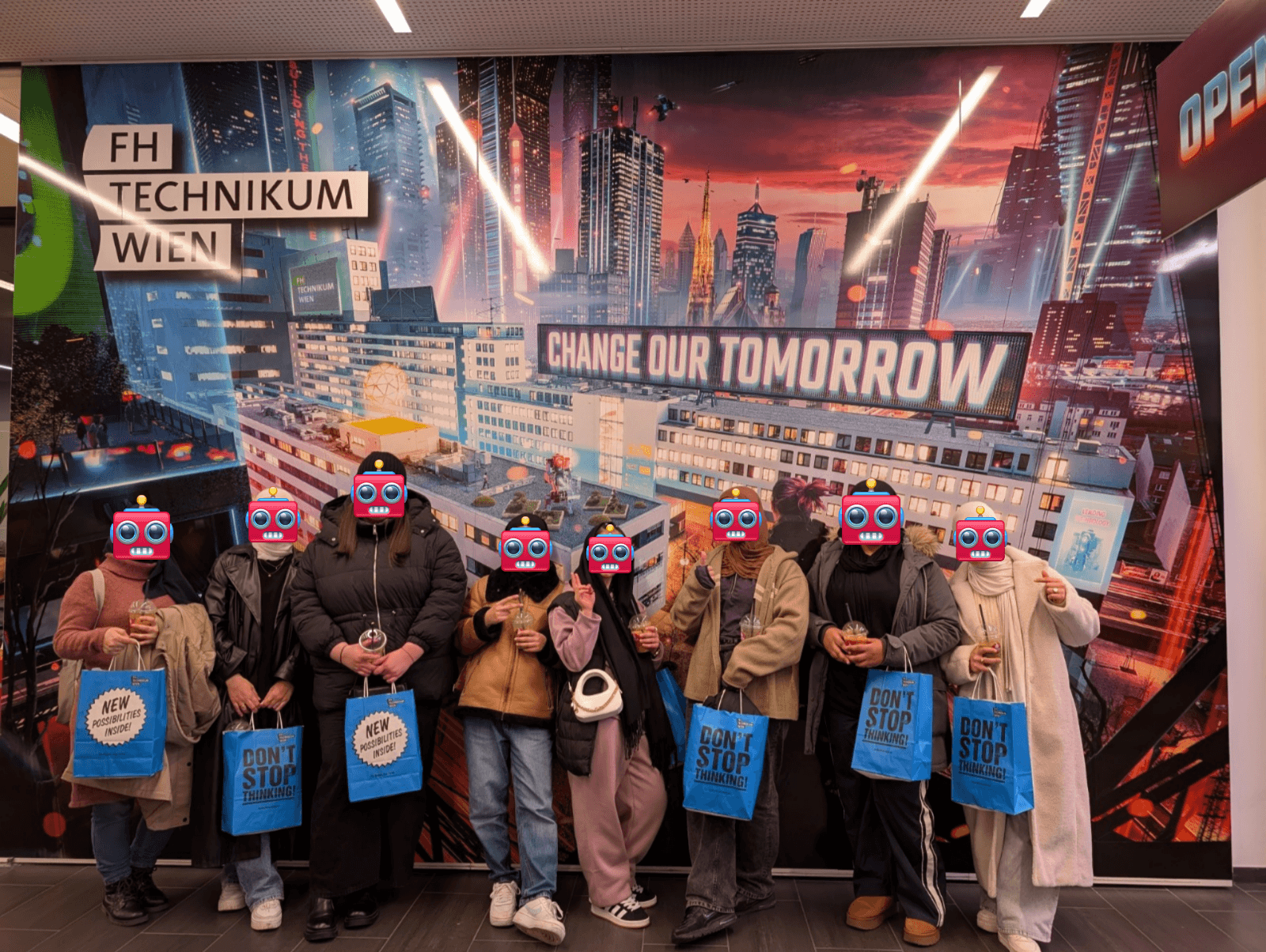 Eine Gruppe von neun Personen steht vor einem farbenfrohen Stadtbild mit der Aufschrift CHANGE OUR TOMORROW. Sie halten blaue Taschen und Getränke in der Hand, und jedes Gesicht ist mit einer rosa Cartoon-Robotermaske bedeckt.