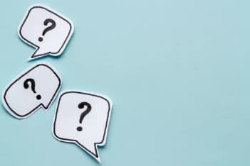 Drei weiße Sprechblasen mit schwarzen Fragezeichen im Inneren sind auf einem hellblauen Hintergrund angeordnet und deuten auf Neugier oder Fragen hin.