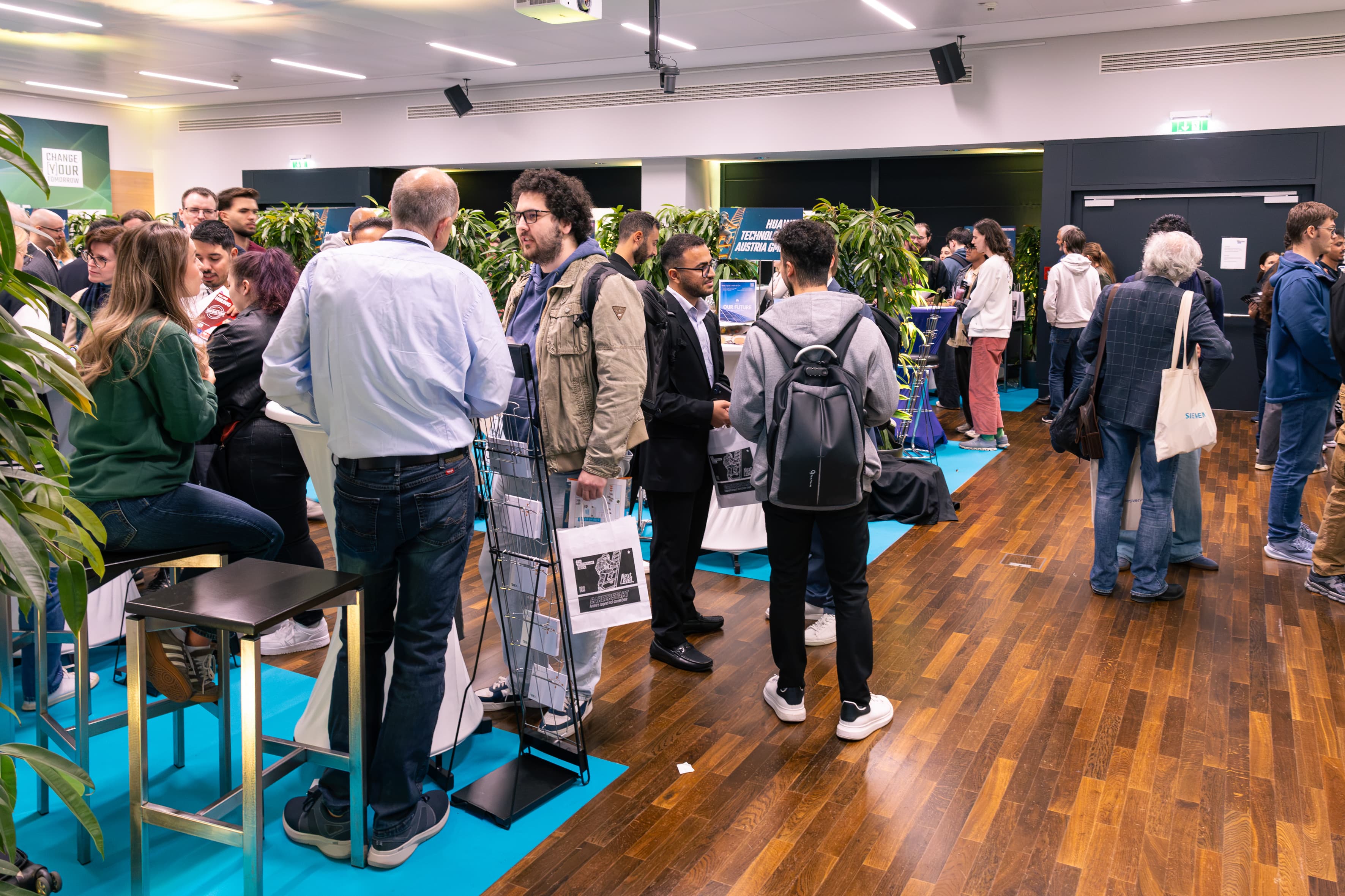 Eine Gruppe von Menschen, die während einer Networking-Veranstaltung in einem modernen Büroraum stehen und sich unterhalten.
