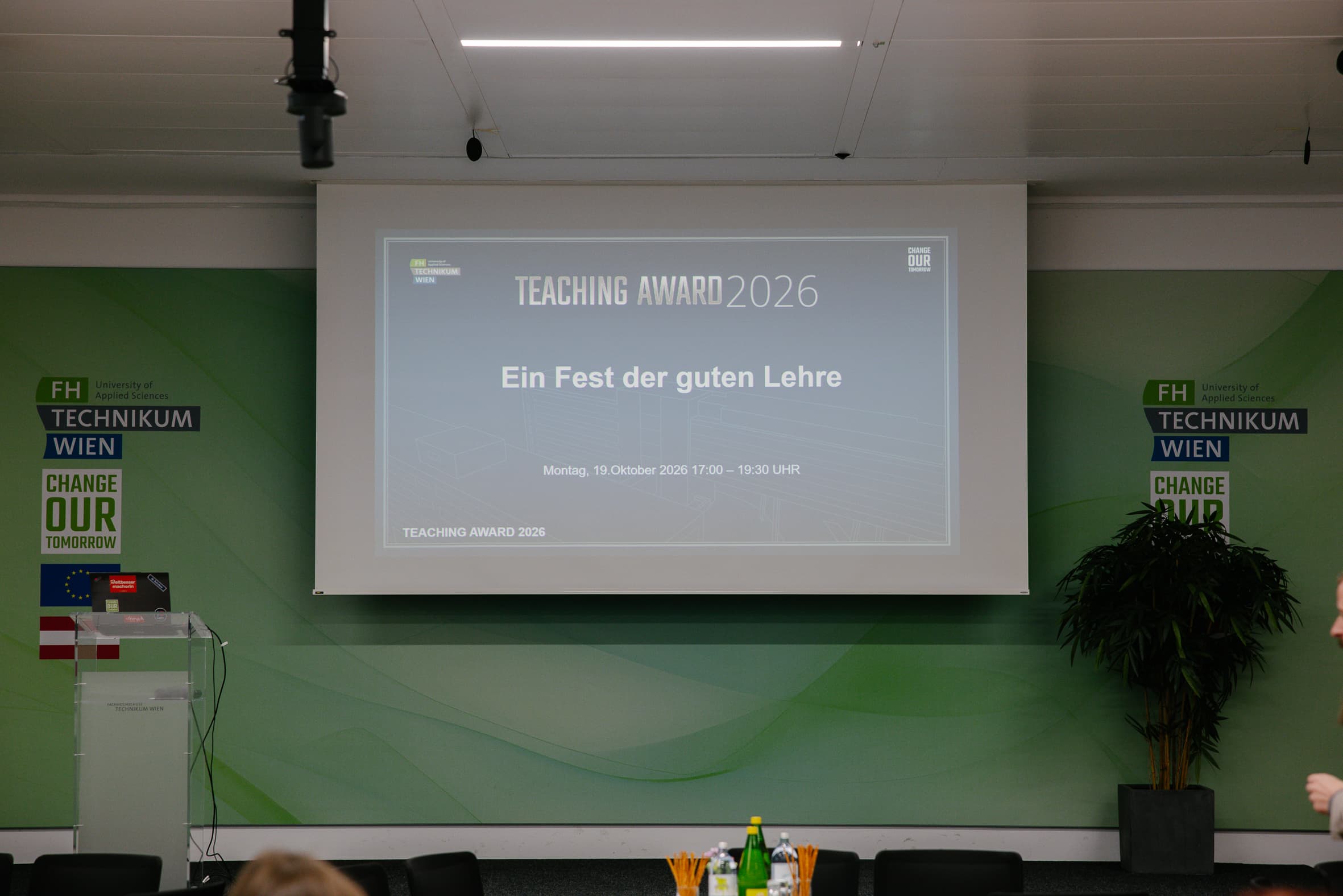 Projektionsleinwand mit dem Titel der Veranstaltung TEACHING AWARD 2026 – Ein Fest der guten Lehre –, die für Montag, den 19. Oktober 2026, an der Fachhochschule Technikum Wien geplant ist.